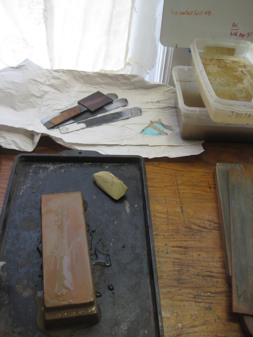 The 6000 grit water stone with nigura stone in the foreground. Finishing strop is to the right, and three knife blanks at the back (with my own lifting knife in its sheath on top).